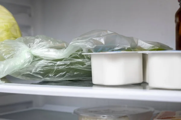 Planken van een open frige koelkast met verschillende levensmiddelen — Stockfoto