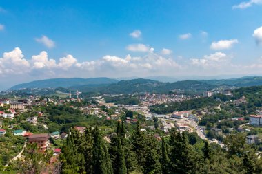 Blue coast of Black Sea in Sochi with houses and mountains, aerial panoramic view