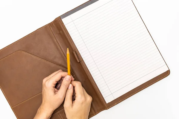 Les mains de la femme tenant un cahier et un crayon jaune et l'écriture, fermer l'espace de copie vue du dessus — Photo