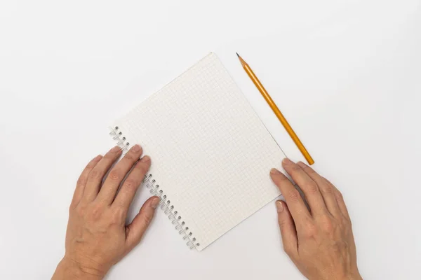Kadın elleri bir defter ve yazmaya hazır sarı bir kalem tutuyor. Üst görünüm kopya alanını kapatın. — Stok fotoğraf