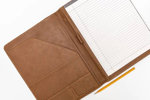 An open business notebook organiser with leather cover and a yellow pencil on white background, top view copy space