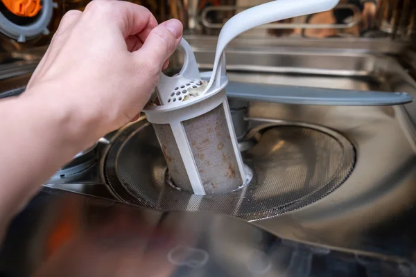 Una mano sacando un filtro de desagüe sucio de la lavadora de platos de cerca — Foto de Stock