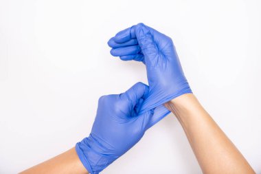 Doktor ya da hemşire mavi nitril cerrahi eldiven, profesyonel tıbbi güvenlik ve beyaz arka plan için hijyen ve sağlık muayenesi yapıyor.