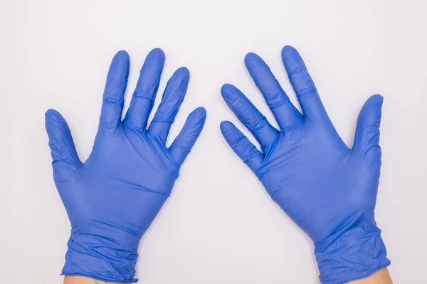 Mains humaines portant des gants en nitrile de latex chirurgical bleu pour la protection du médecin et de l'infirmière pendant l'examen du patient sur fond blanc — Photo