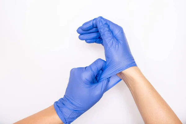 Médico ou enfermeiro vestindo luvas cirúrgicas de nitrilo azul, segurança médica profissional e higiene para cirurgia e exame médico em fundo branco — Fotografia de Stock