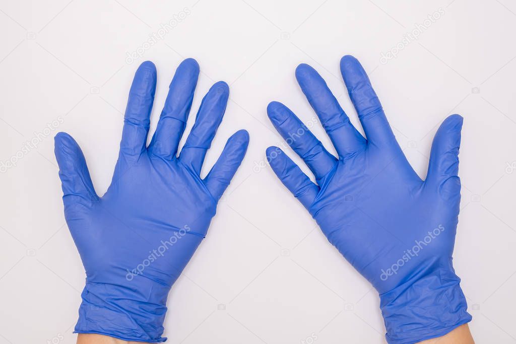 Human hands wearing blue surgical latex nitrile gloves for doctor and nurse protection during patient examination on white background