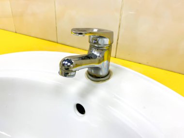 A dirty modern faucet, water tap with limescale on a water bowl, basin in bathroom at home