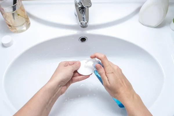 Mujer mojando una almohadilla de algodón con un removedor de maquillaje micelar, limpiando y purificando la piel de la cara — Foto de Stock