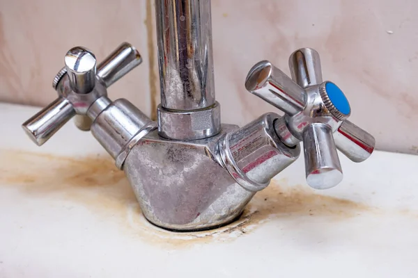 Detail of faucet with limescale or lime scale on it, dirty calcified and rusty kitchen mixer tap, close up