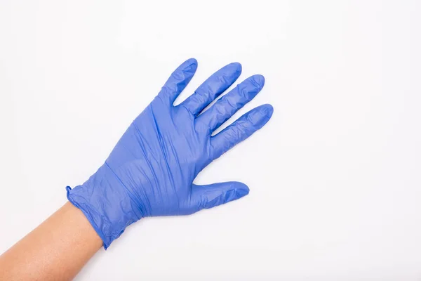 Main humaine portant un gant en nitrile de latex chirurgical bleu pour la protection du médecin et de l'infirmière pendant l'examen du patient sur fond blanc, espace de copie — Photo