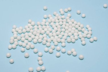 Birçok homeopatik küre pastel mavi arka plana dağılmış durumda. Alternatif homeopati tıp konsepti, kapatın.
