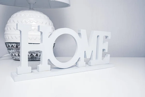 Lámpara de noche de cerámica con pantalla textil en la mesa blanca con el signo de inicio, acogedor concepto de hogar en colores pastel grises —  Fotos de Stock
