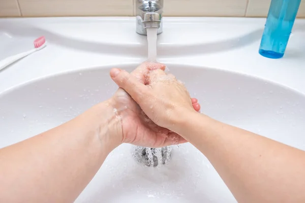 Mujer lavándose las manos bajo el grifo con agua, higiene y concepto de perfilería — Foto de Stock