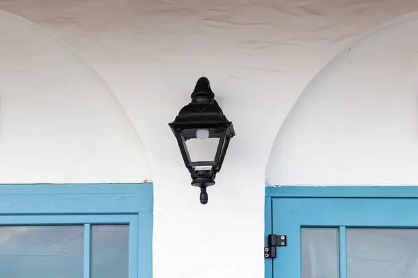 Vintage vieille rue classique lanterne extérieure en fer noir, lampe sur mur de la maison blanche entre deux cadres de fenêtre bleue — Photo