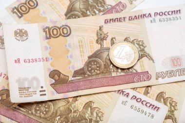 100 rusya rublesinin üzerinde yatan bir euro madeni para. Arkaplan, para birimi döviz kuru konsepti..