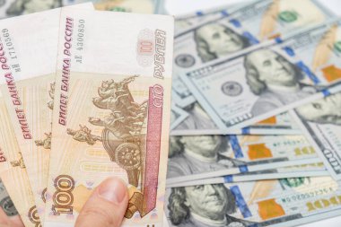 100 ruble ve Amerikan doları banknotları tutan bir el arka plan, ruble devalüasyon ve usd-ovuşturma kuru kavramı.