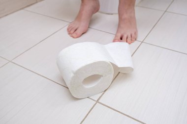 Tuvalette bir rulo tuvalet kağıdıyla oturan bir çocuğun kesilmiş bacakları, sindirim sorunları ve tuvalet kavramındaki zorluklar..