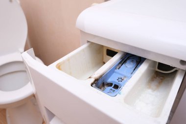 Kirli, küflü çamaşır makinesi deterjanı ve kumaş kremi kutusunun çekmecesini kapat. Küf, pas ve kireç rengi çamaşır makinesi tepsisi. Ev aletleri periyodik bakım kavramı.