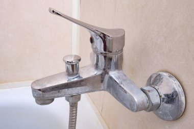 Kirli kireçlenmiş duş karıştırıcı musluğu, üzerinde kireç pulu olan musluk, kapat.