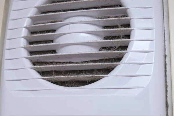 Extremely dirty and dusty white plastic ventilation air grille at home close up, harmful for health, house cleaning concept..