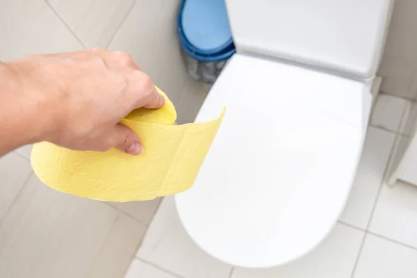 Hand Som Håller Rulle Gult Toalettpapper Toalett Toalett Matsmältningsproblem Koncept — Stockfoto