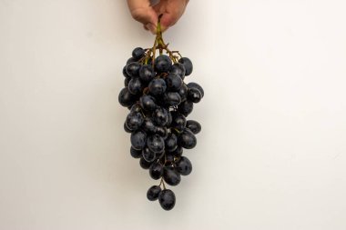 Bir demet üzümü siyah beyaz tutarak.