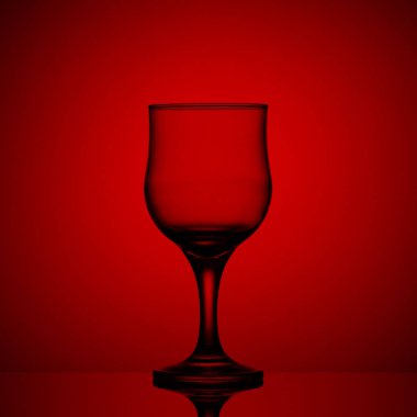 Kırmızı arka planda boş şarap kadehi