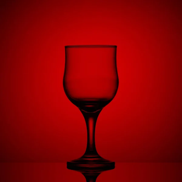 Copo de vinho vazio em um fundo vermelho — Fotografia de Stock