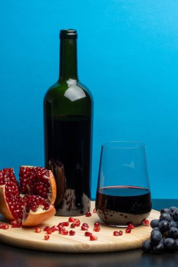 Bir şişe şarap, bir bardak, üzüm ve nar..