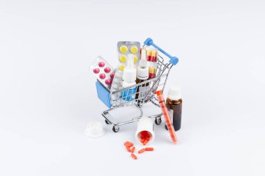Beyaz arka plan üzerinde ilaçlarla alışveriş sepeti