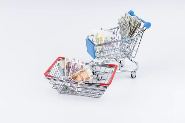 Carrinho de compras com dinheiro no fundo branco — Fotografia de Stock