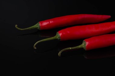 Siyah ayna arka planında kırmızı biber.