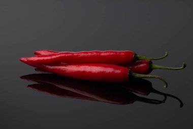 Siyah ayna arka planında kırmızı biber.