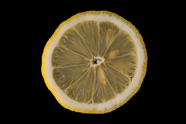 sliced lemon with seeds on a black background