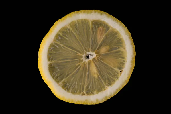 Limão fatiado com sementes em um fundo preto Fotos De Bancos De Imagens