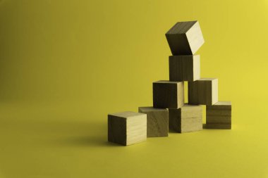 Sarı arka planda tahta bloklar.