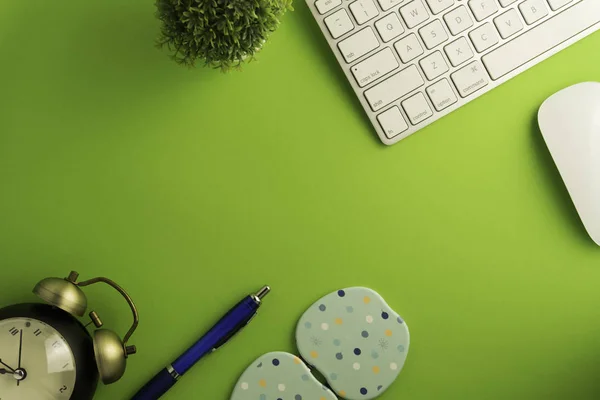 Yeşil arkaplan ofis masasındaki boş sayfa üst görünümü 