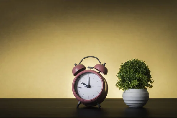 Reloj despertador rosa sobre fondo marrón. Concepto de tiempo . — Foto de Stock