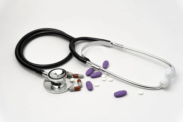 Medicin, medicin stetoskop och piller på vit bakgrund. Sjukvård eller sjukdom. Tabletter eller läkemedel på sjukhus eller apotek. Hjärtbehandling. Receptbelagt läkemedel — Stockfoto