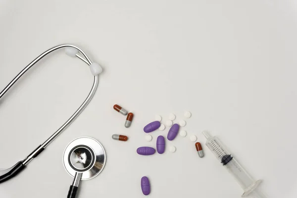 Tıbbi, tıbbi steteskop ve beyaz arka planda haplar. Sağlık hizmeti ya da hastalık. Hastanede ya da eczanede ilaç ya da tablet. Kardiyoloji kalp tedavisi. İlaç reçetesi