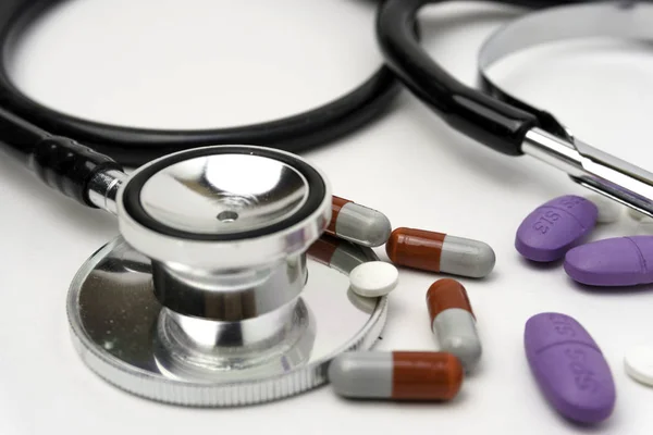 Medicin, medicin stetoskop och piller på vit bakgrund. Sjukvård eller sjukdom. Tabletter eller läkemedel på sjukhus eller apotek. Hjärtbehandling. Receptbelagt läkemedel — Stockfoto