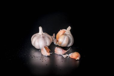 Karanlık bir arka planda sarımsağın sanatsal resmi. Sarımsaklı birkaç baş sarımsak..