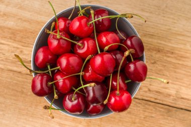 Ahşap bir masa üzerinde bir kase kiraz.