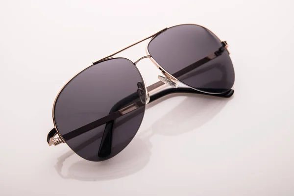 Sonnenbrille auf farbiger Glasoberfläche. — Stockfoto