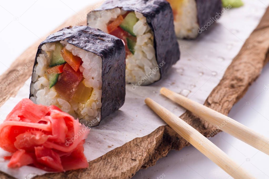 Delicious fresh sushi rolls served on a wooden rustic table.