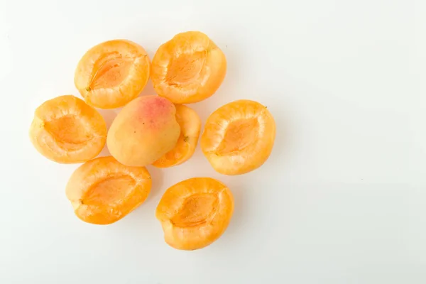 Mitades de albaricoque con semillas, preparadas para cocinar sobre un fondo blanco . — Foto de Stock