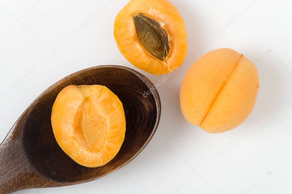 Apricot halves with seeds, prepared for cooking on a white background. 
