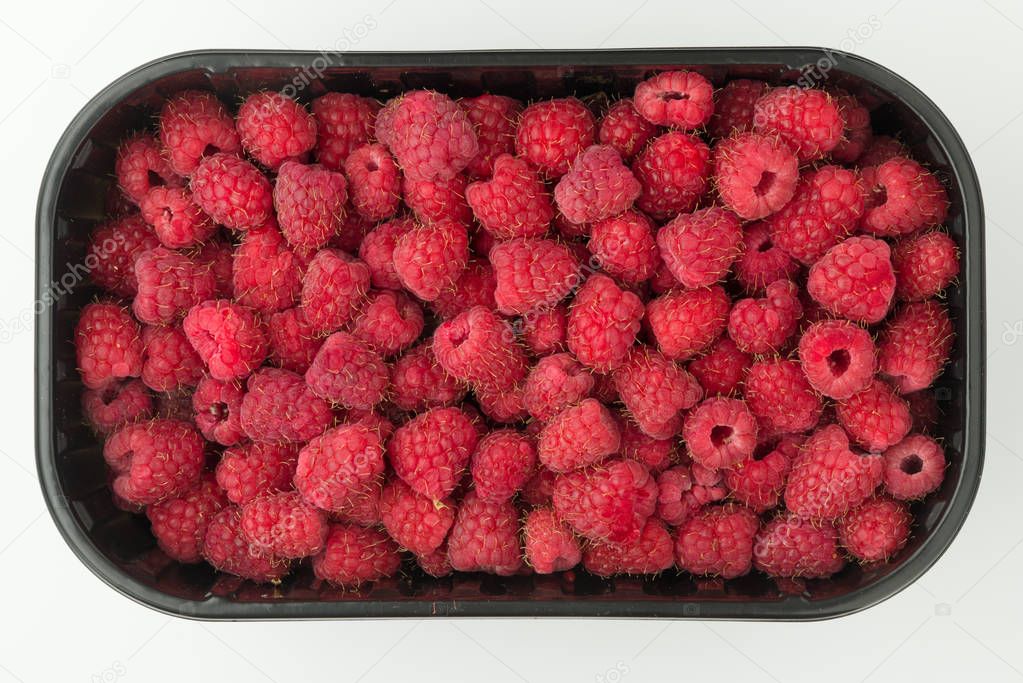 Raspberries in a plastic container. View from above. Closeup.