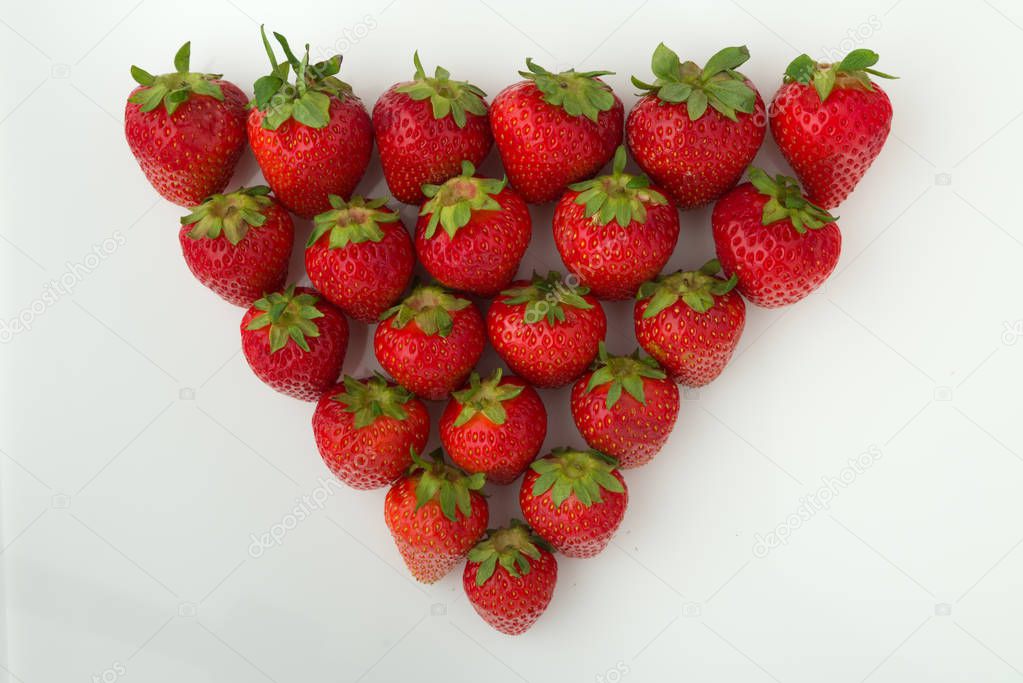 Group of ripe strawberries are arranged as triangle shape.