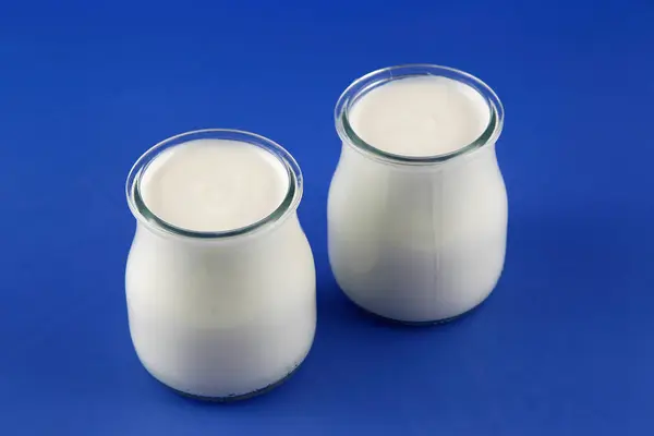 Tubs of natural yogurt, derived from cow's milk. — Stock Photo, Image